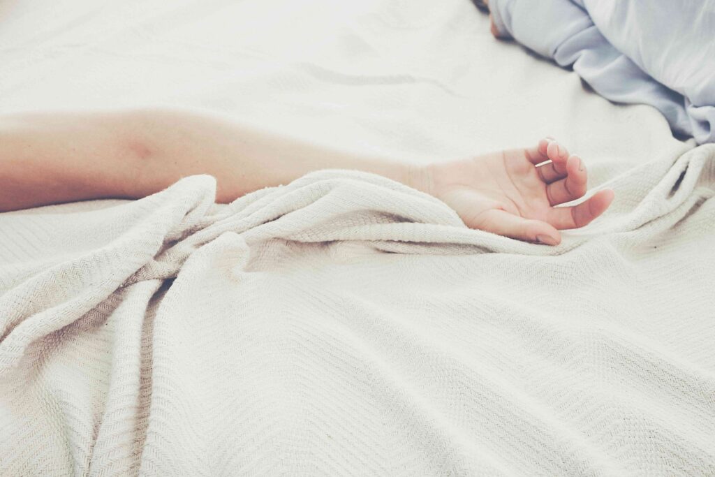 ein Frauenarm ausgestreckt auf dem Bett - Ernährung & Longevity