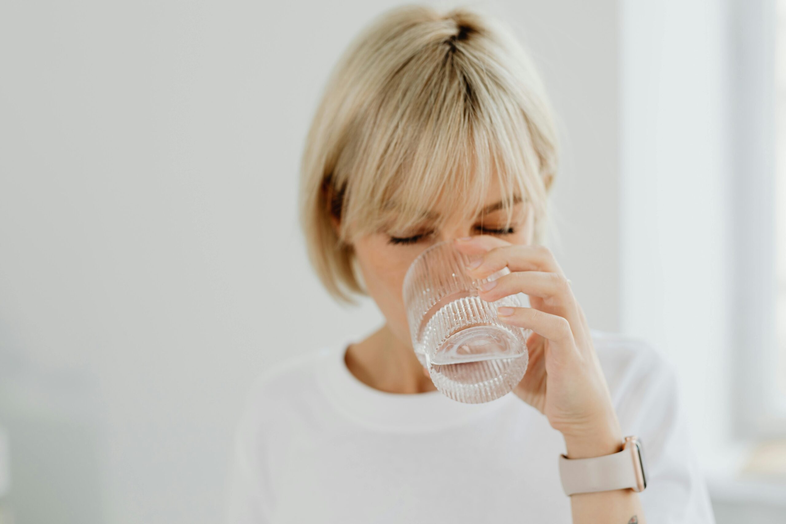 Eine Frau trinkt ein Glas Wasser.
