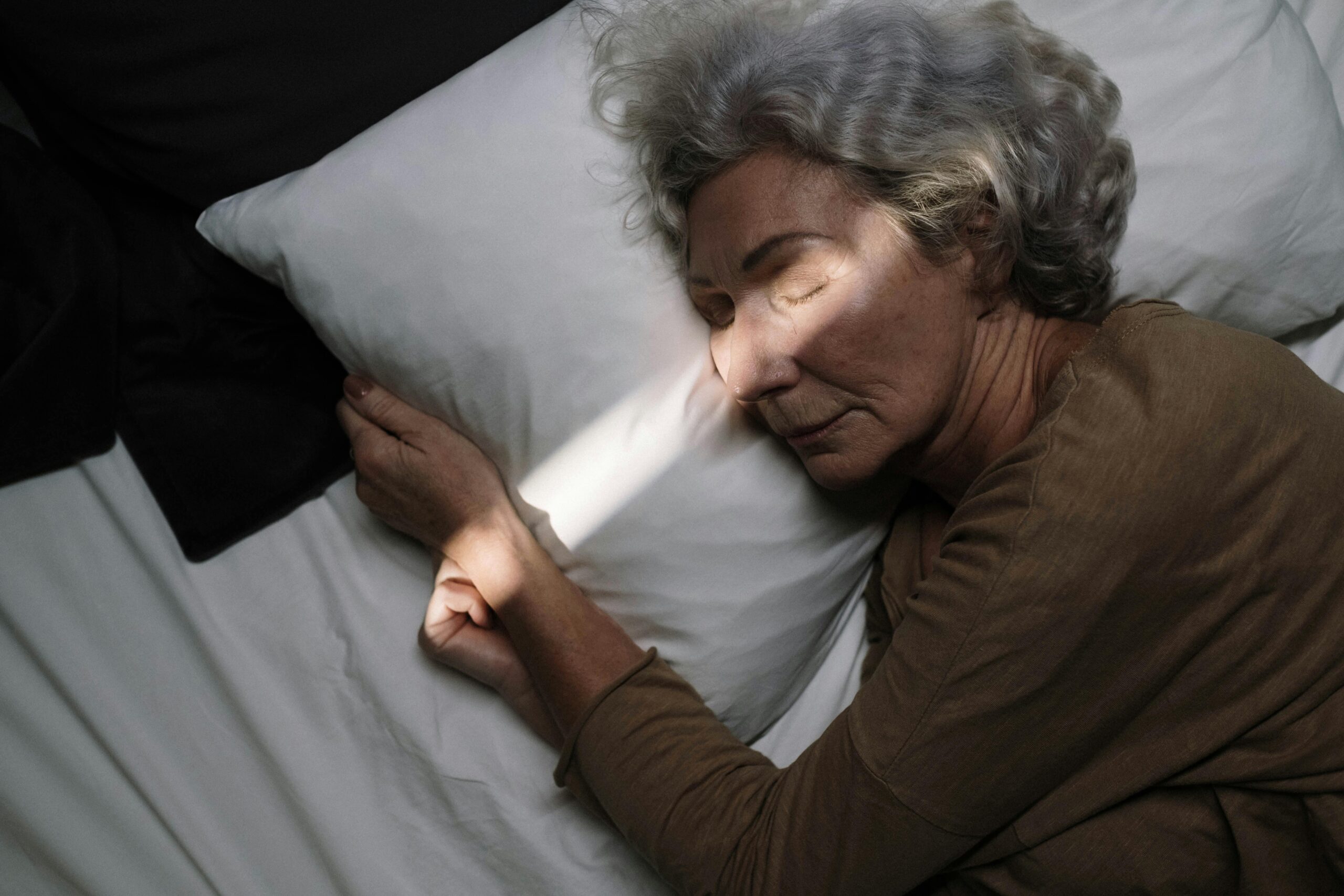 ältere Frau liegt im Bett und schläft