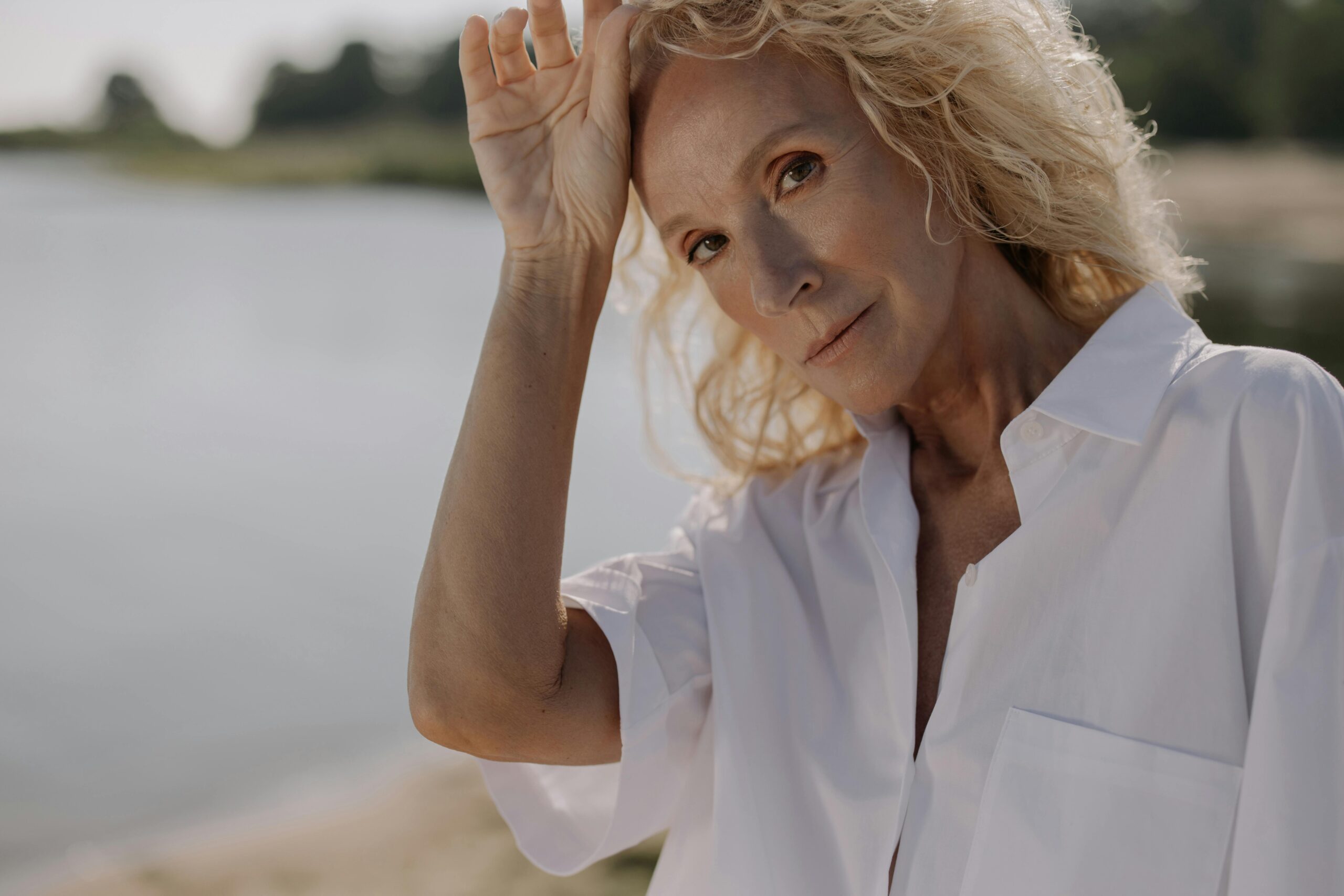 Portrait einer attraktiven Frau mit einem See im Hintergrund -Kollagen ab 50 - Beauty & Anti-Aging
