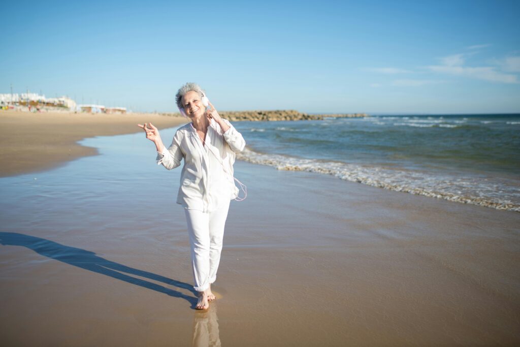 Frau geht am Strand spazieren: Longevity-Lifstyle
