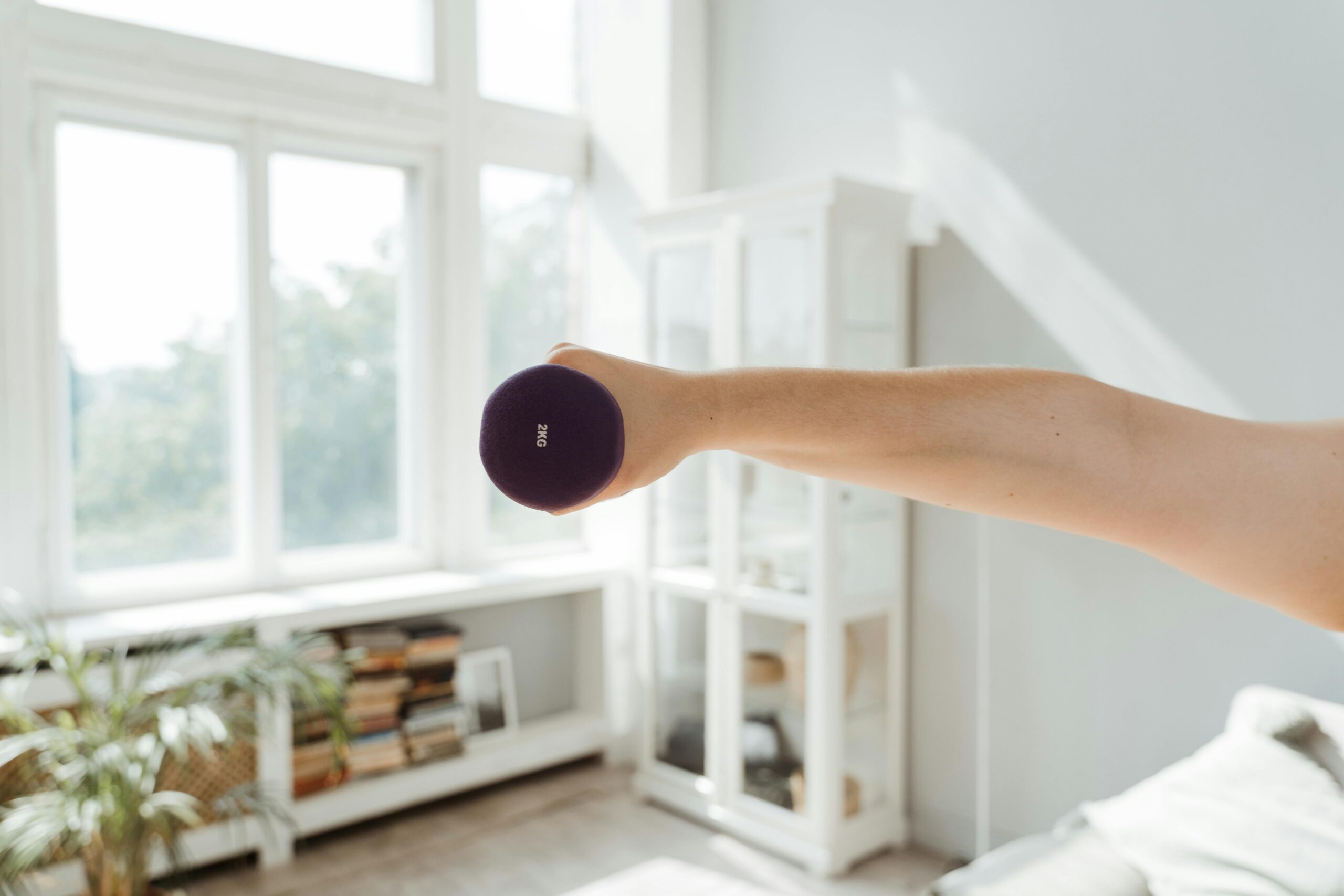 Arm einer Frau, der eine Hantel hoch hebt
