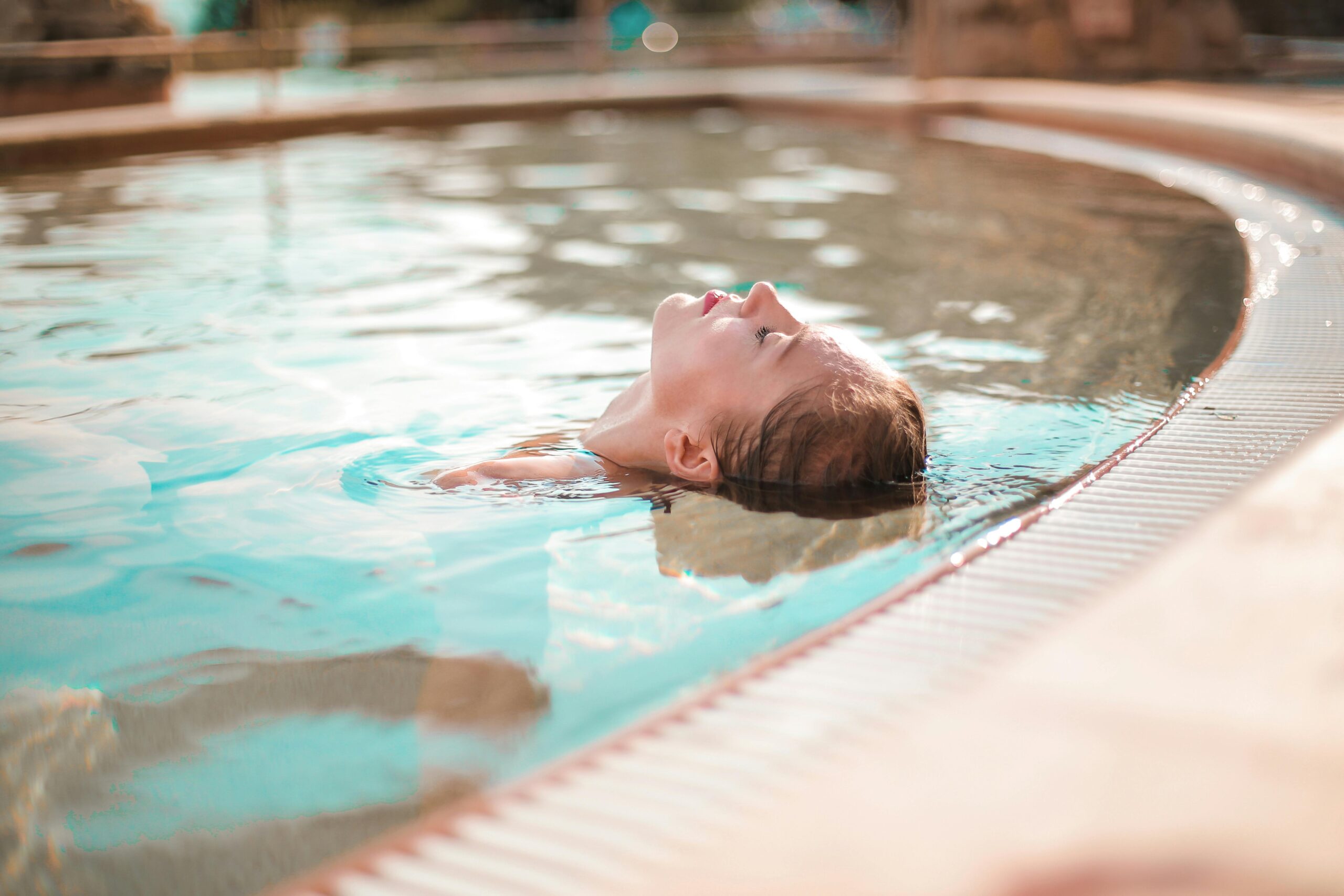 Frau entspannt im Schwimmbecken
