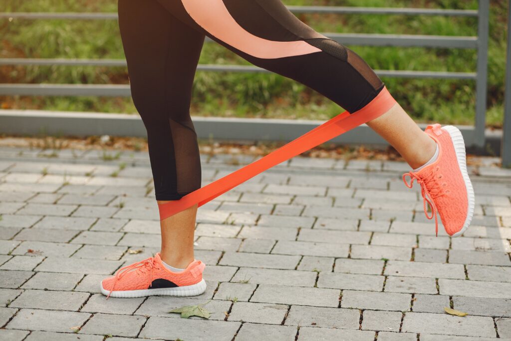 Frau trainiert mit Fitnessband