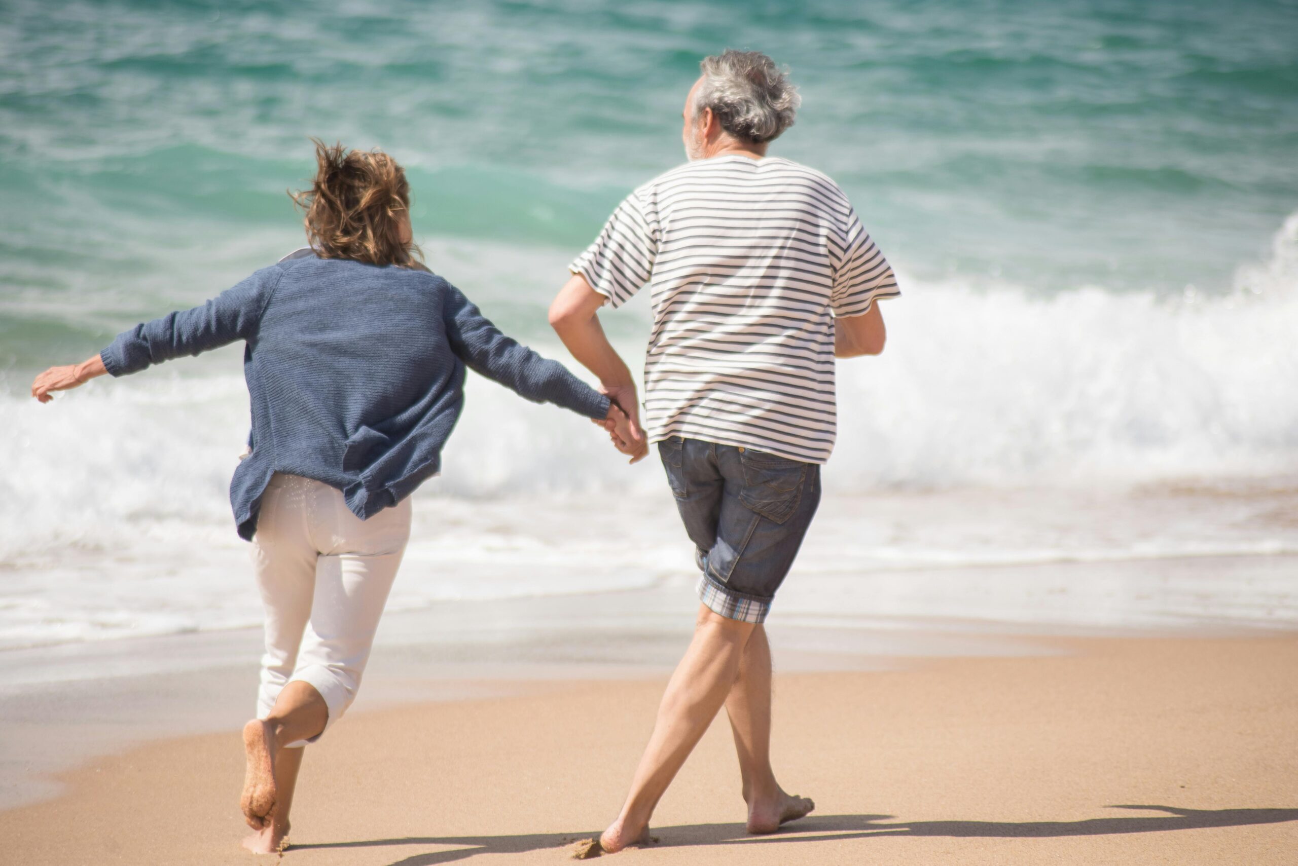 älteres Paar läuft am Strand - Longevity
