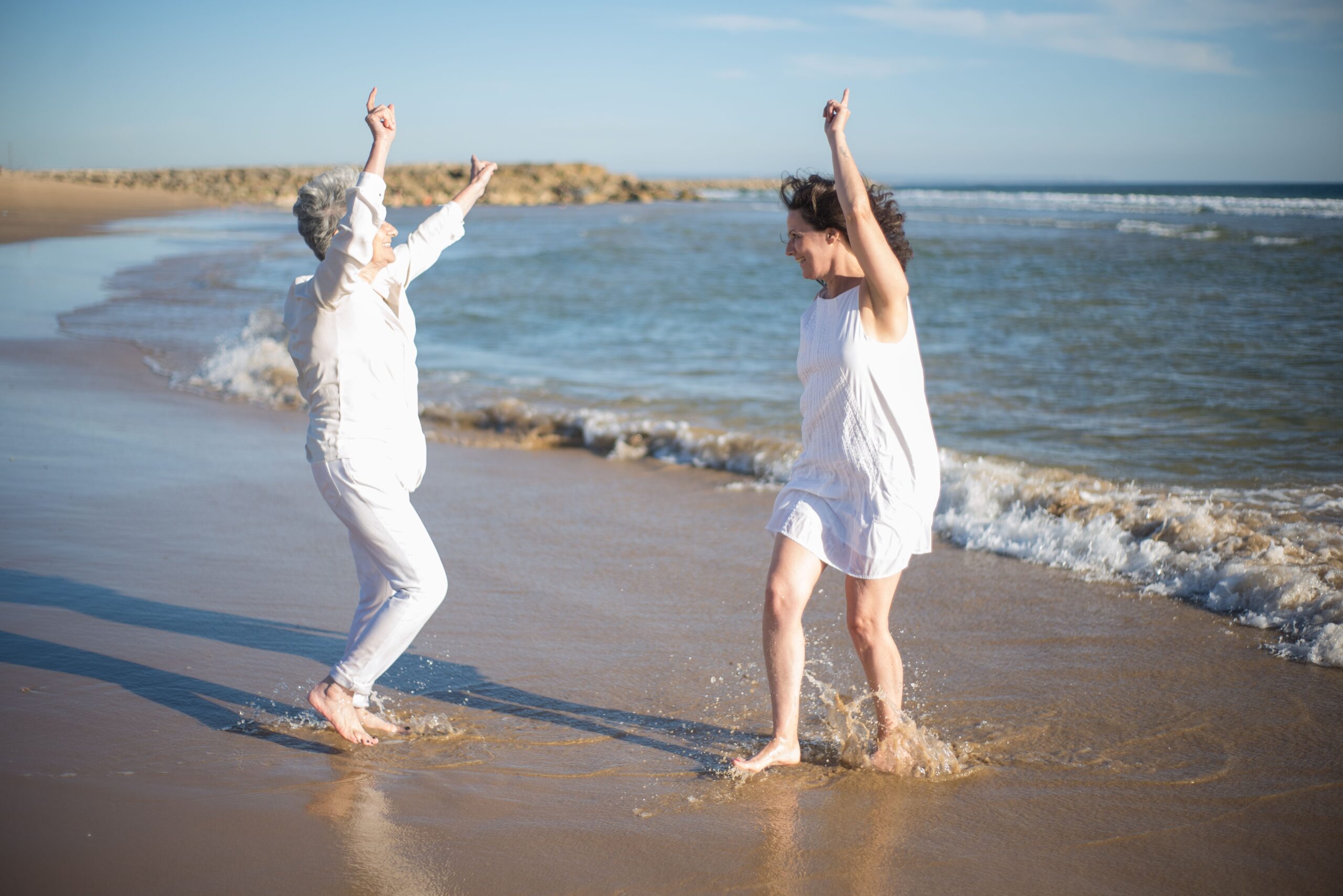 2 Frauen tanzen am Strand