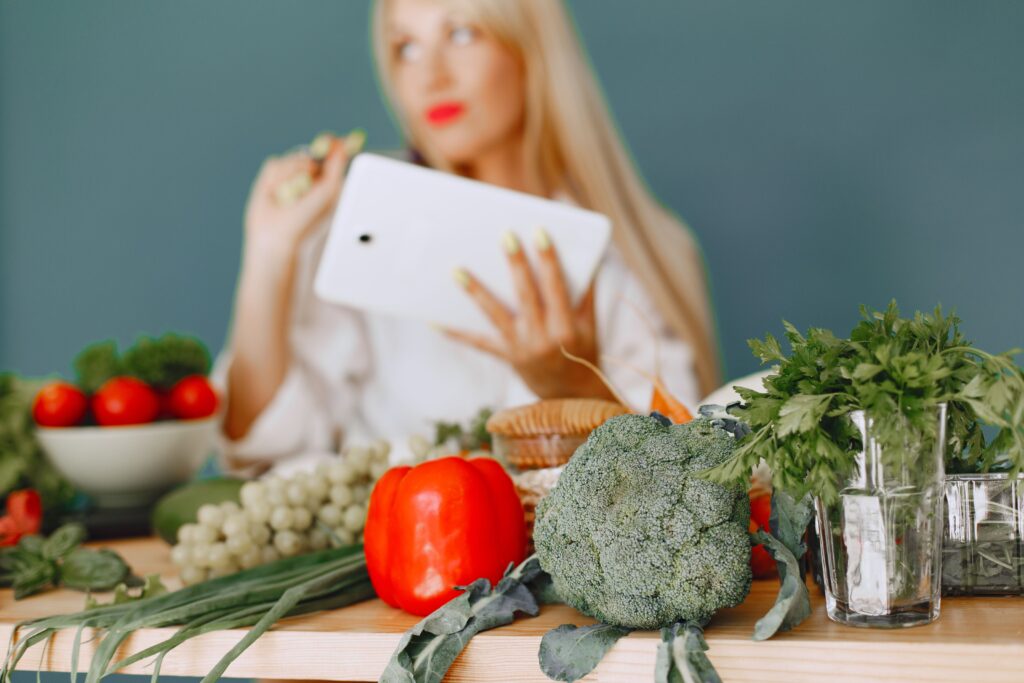Frau in der Küche ermittelt etwas auf ihrem Tablet
