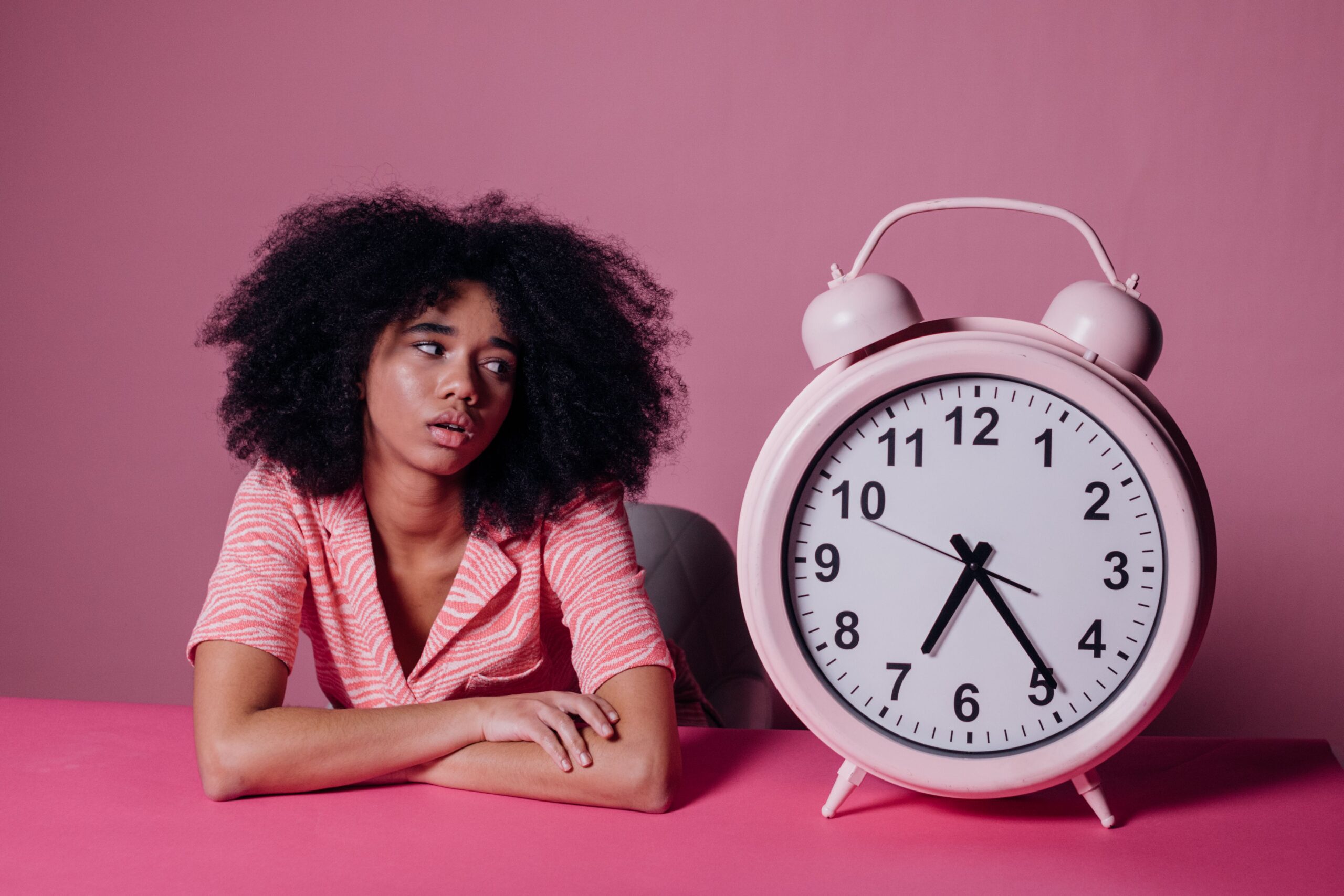 Frau schaut auf große Uhr